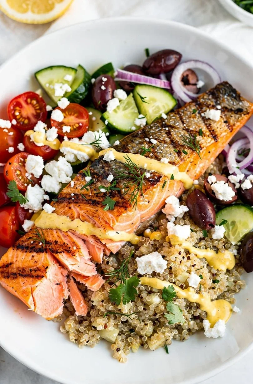 Mediterranean salmon quinoa bowl with fresh vegetables and herbs