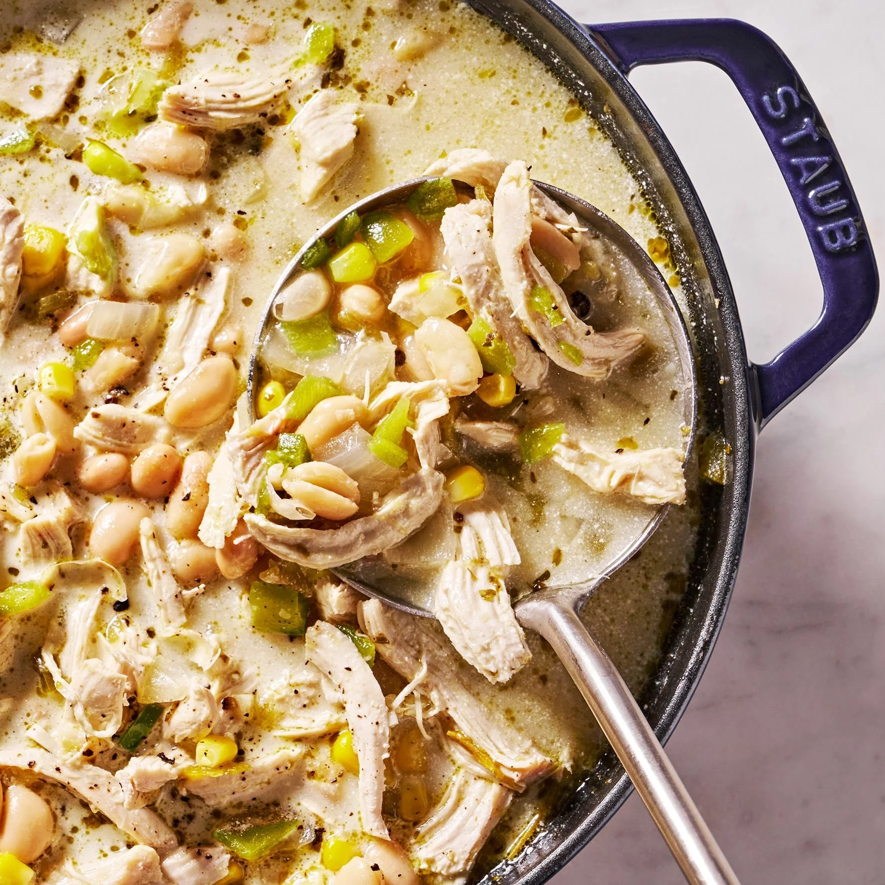 Delicious bowl of white chicken chili topped with cilantro and jalapeños